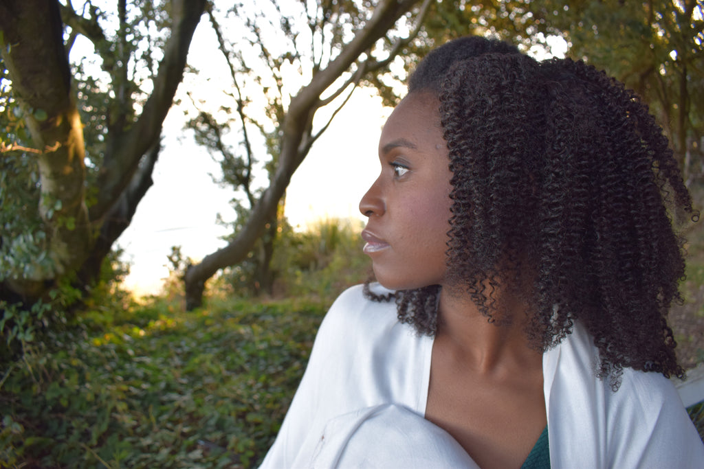 Black women wearing 4a 4b hair clip ins surrounded by greenery
